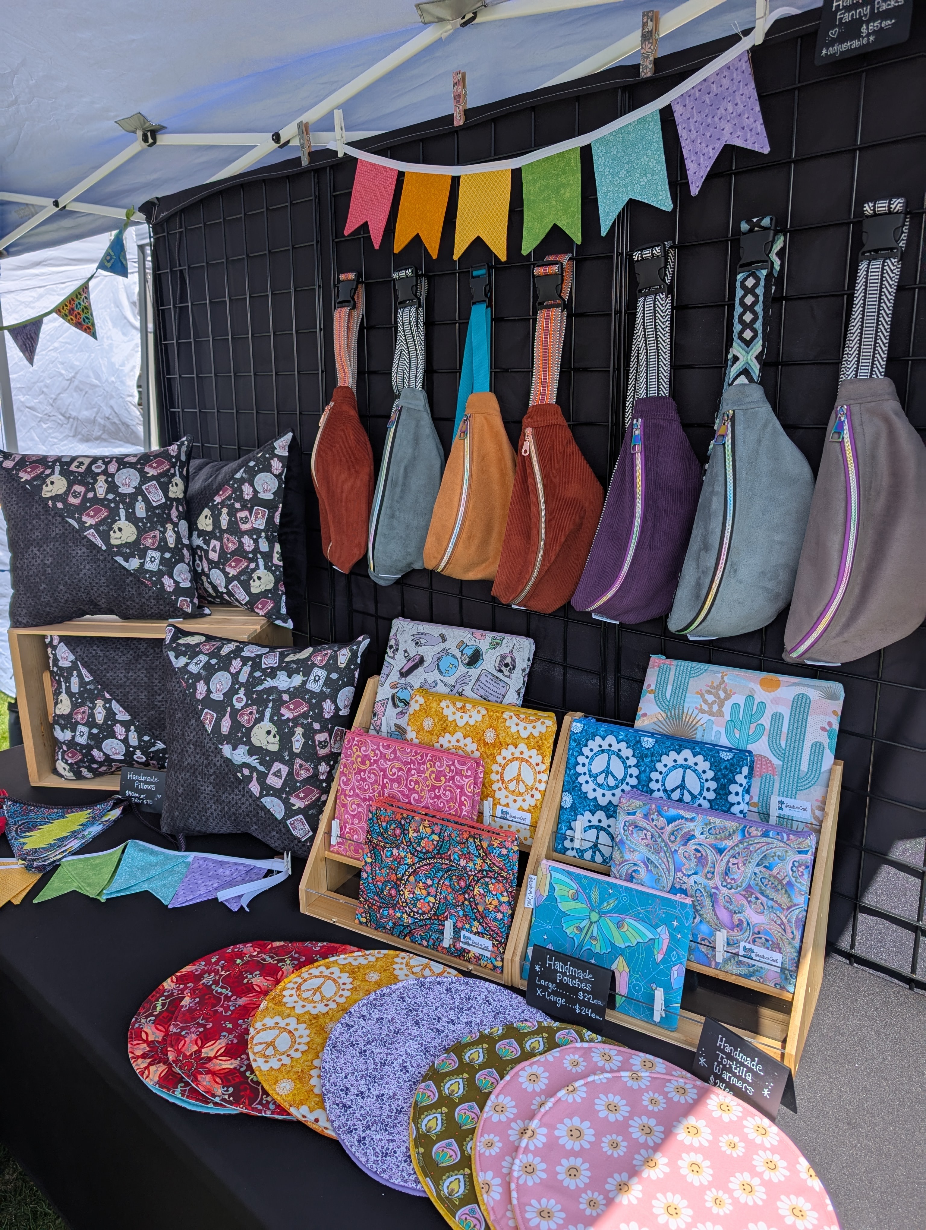 Display of colorful guitar straps, bags, and accessories on a black grid wall with a banner above.