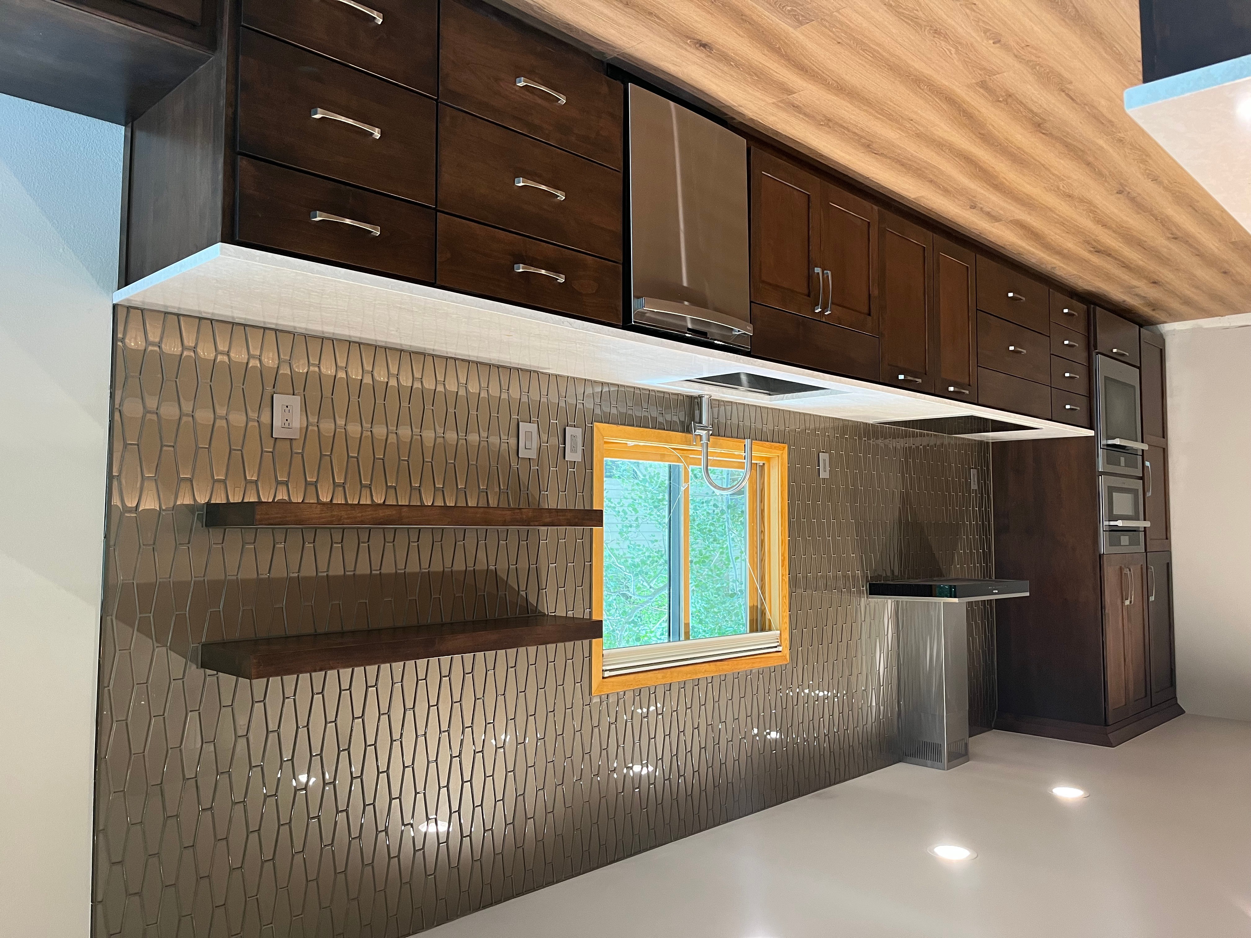 Kitchen with dark wooden cabinets, a window, and a patterned backsplash wall.