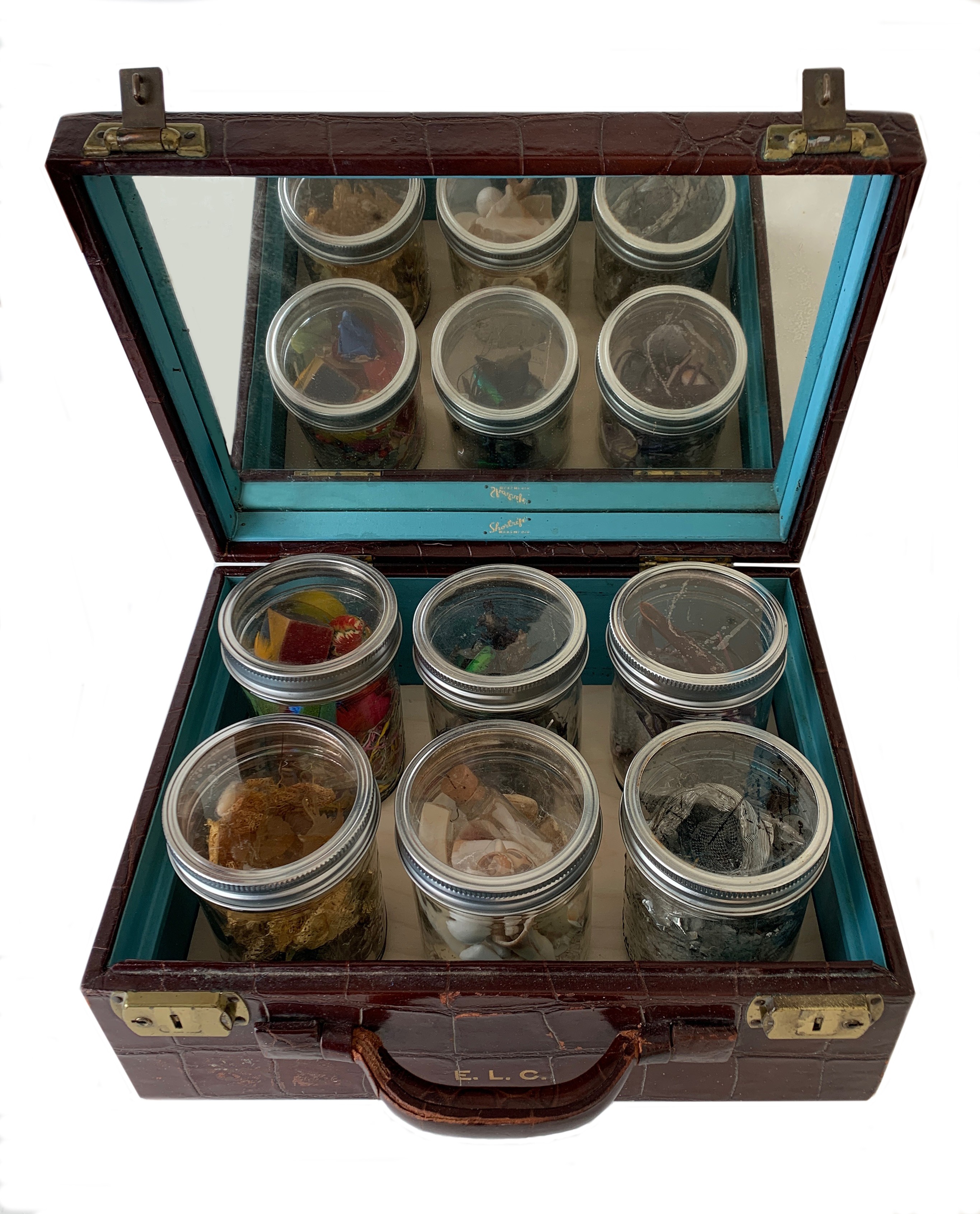 Open glass display case with small containers of food inside, viewed from above. Six containers on the bottom shelf, six on the top. Alt_text_word_count: 20, confidence: 0.9