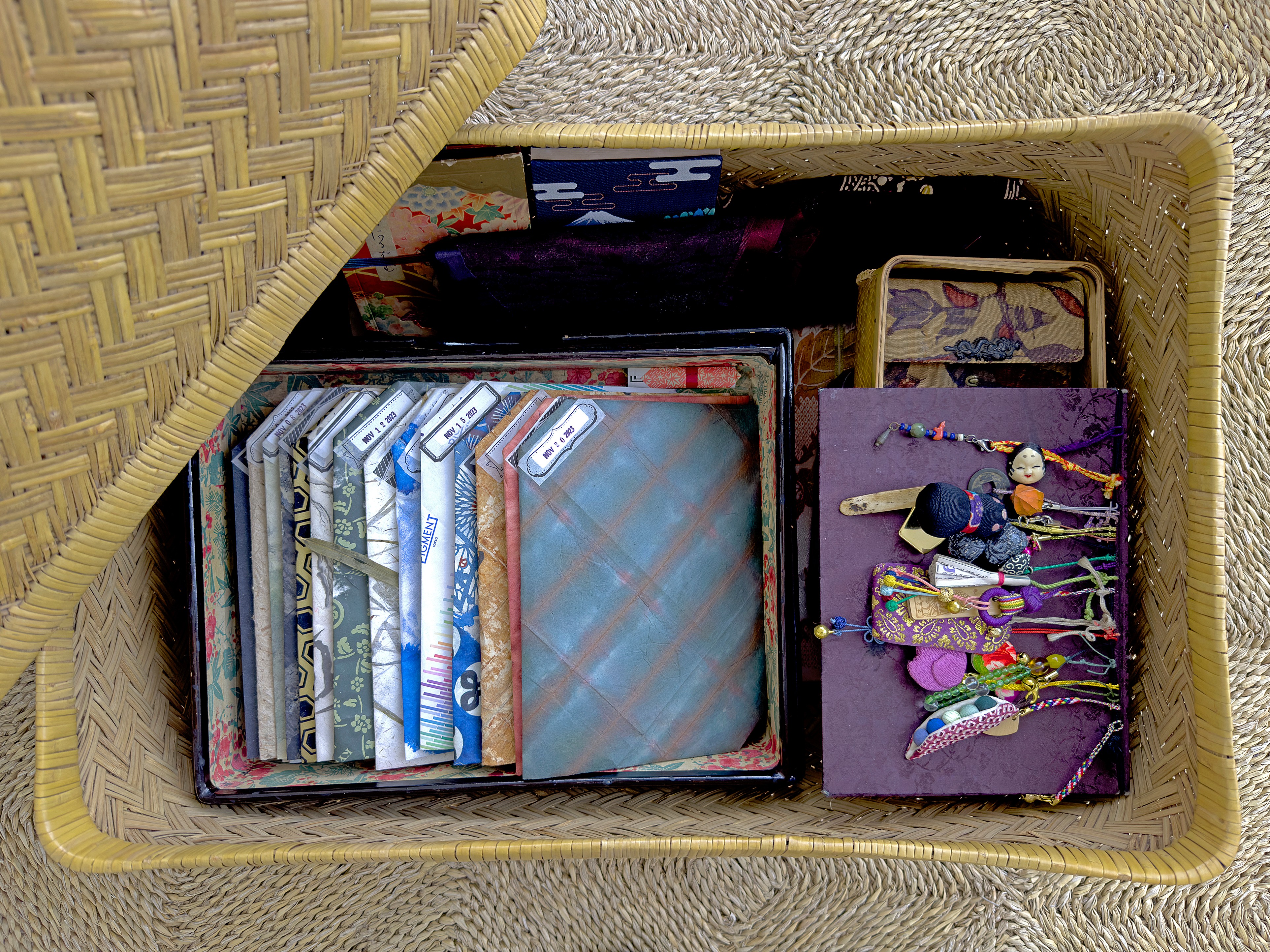 Open woven basket containing playing cards and a purple box with colorful jewelry or accessories inside.