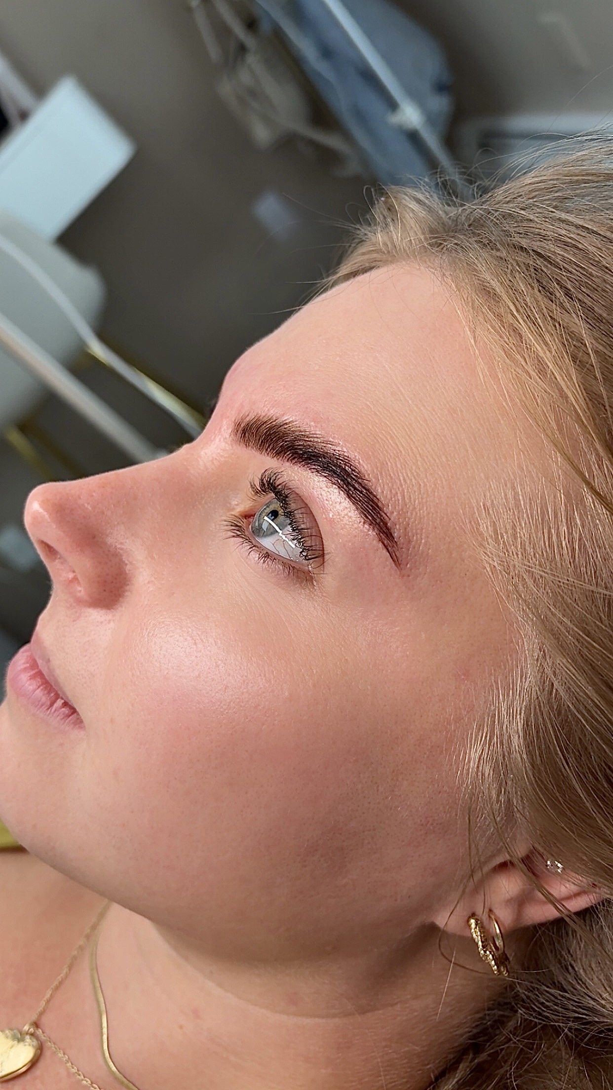 Close-up of a woman's face lying sideways, showing her eye, eyebrow, and part of her cheek and lips.