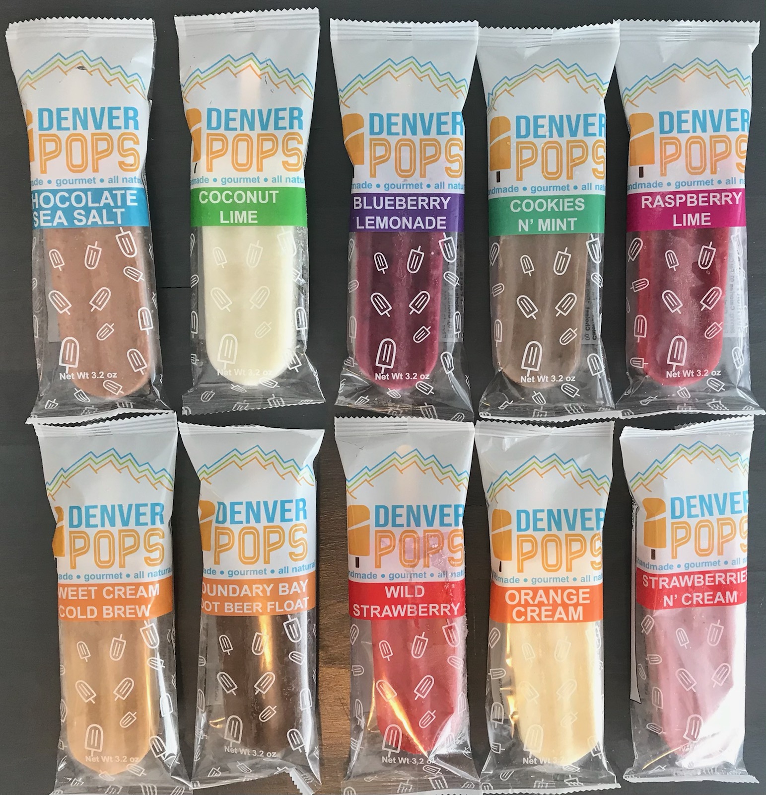 Ten ice cream bars in colorful packaging with flavors like chocolate, coconut lime, blueberry lemonade, and raspberry lime, arranged in two rows.