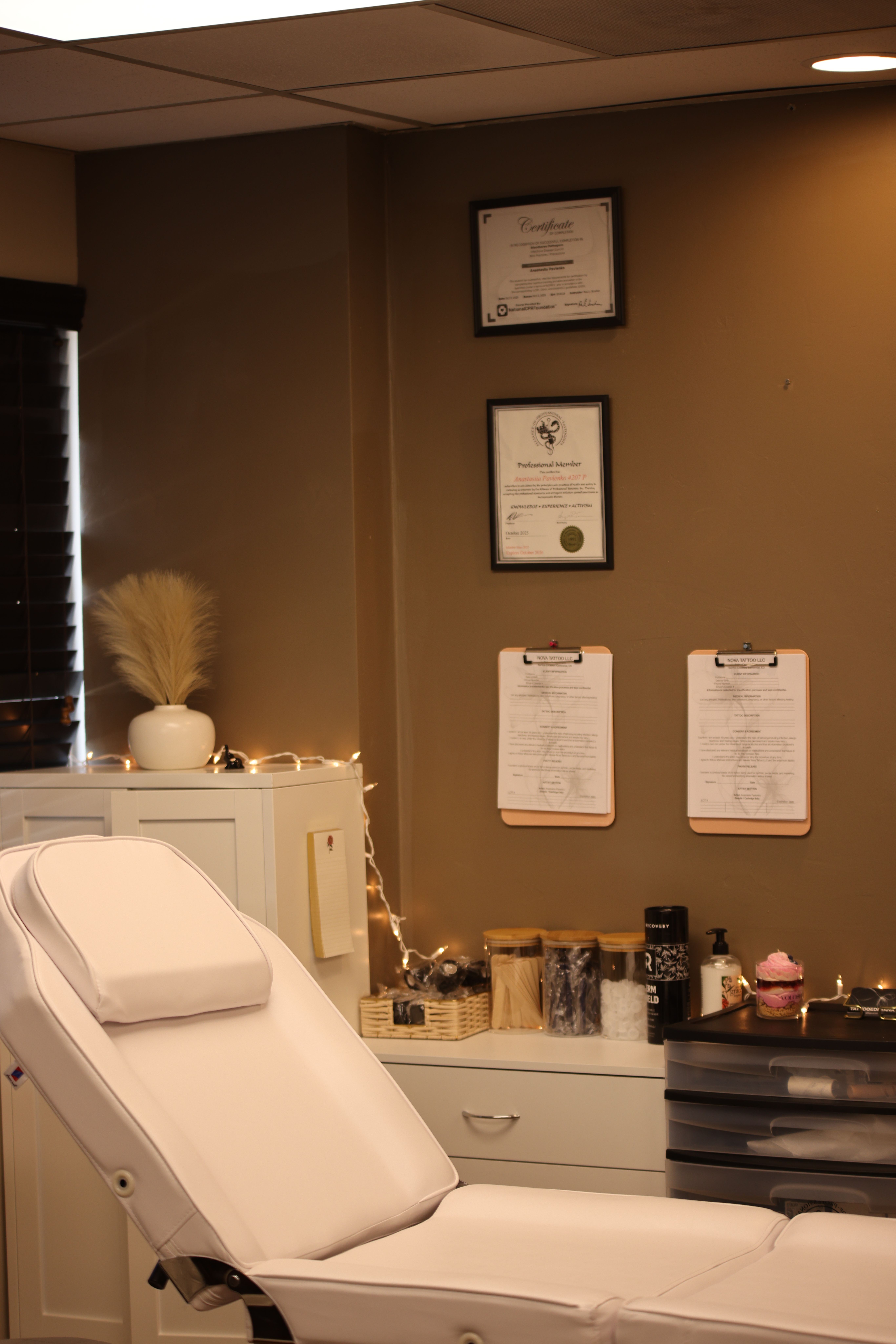 Bathroom with a toilet, vanity, and framed certificates on the wall, illuminated by ceiling lights.