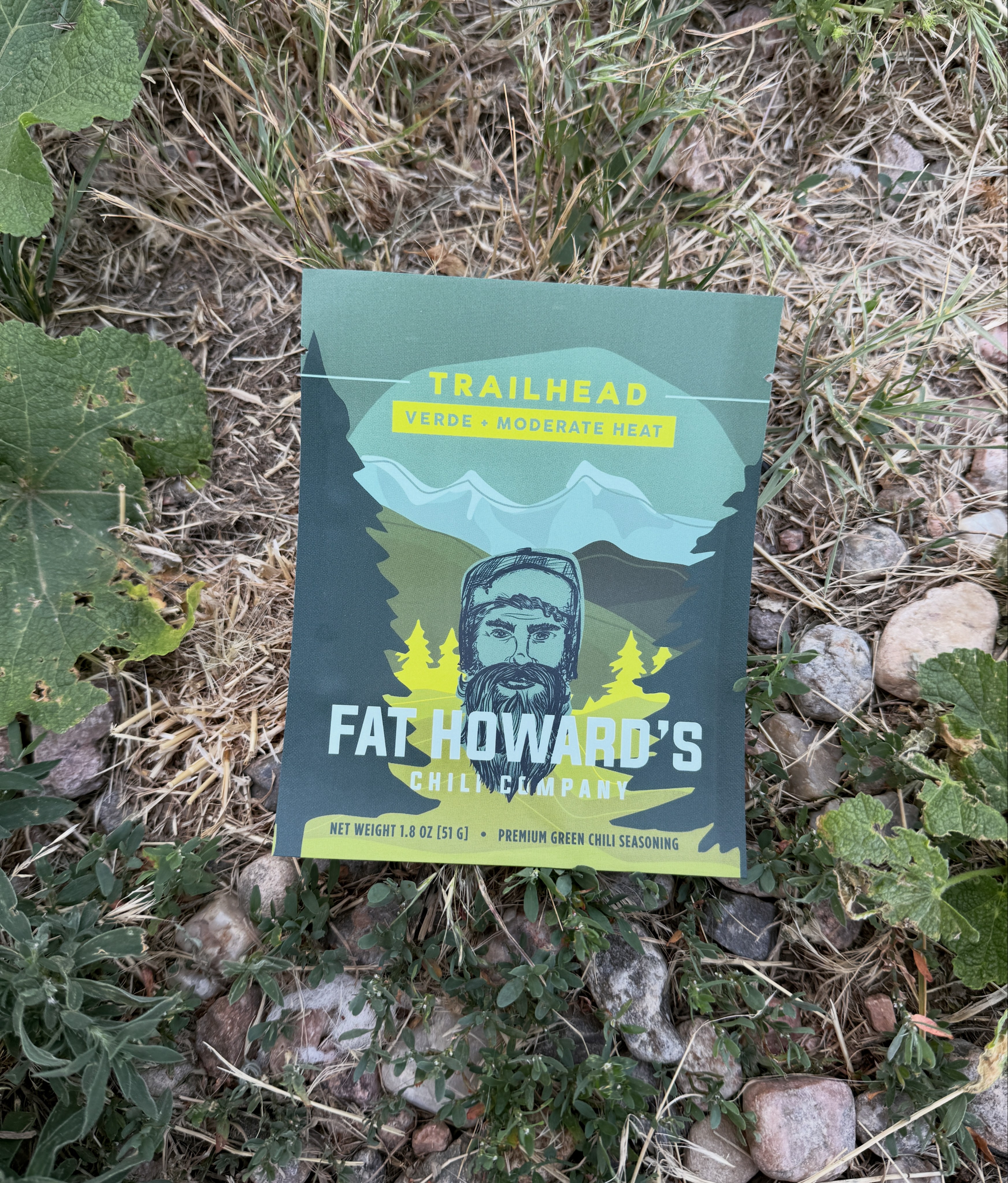 Book cover titled 'Trailhead' featuring a mountain landscape and a bearded man with glasses, surrounded by nature, with text about a hike.