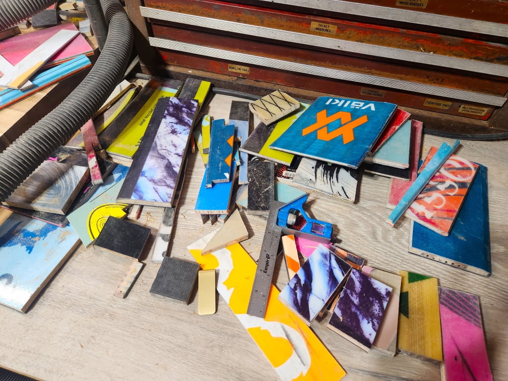Books and notebooks scattered on a wooden surface with a stack of books in the background.