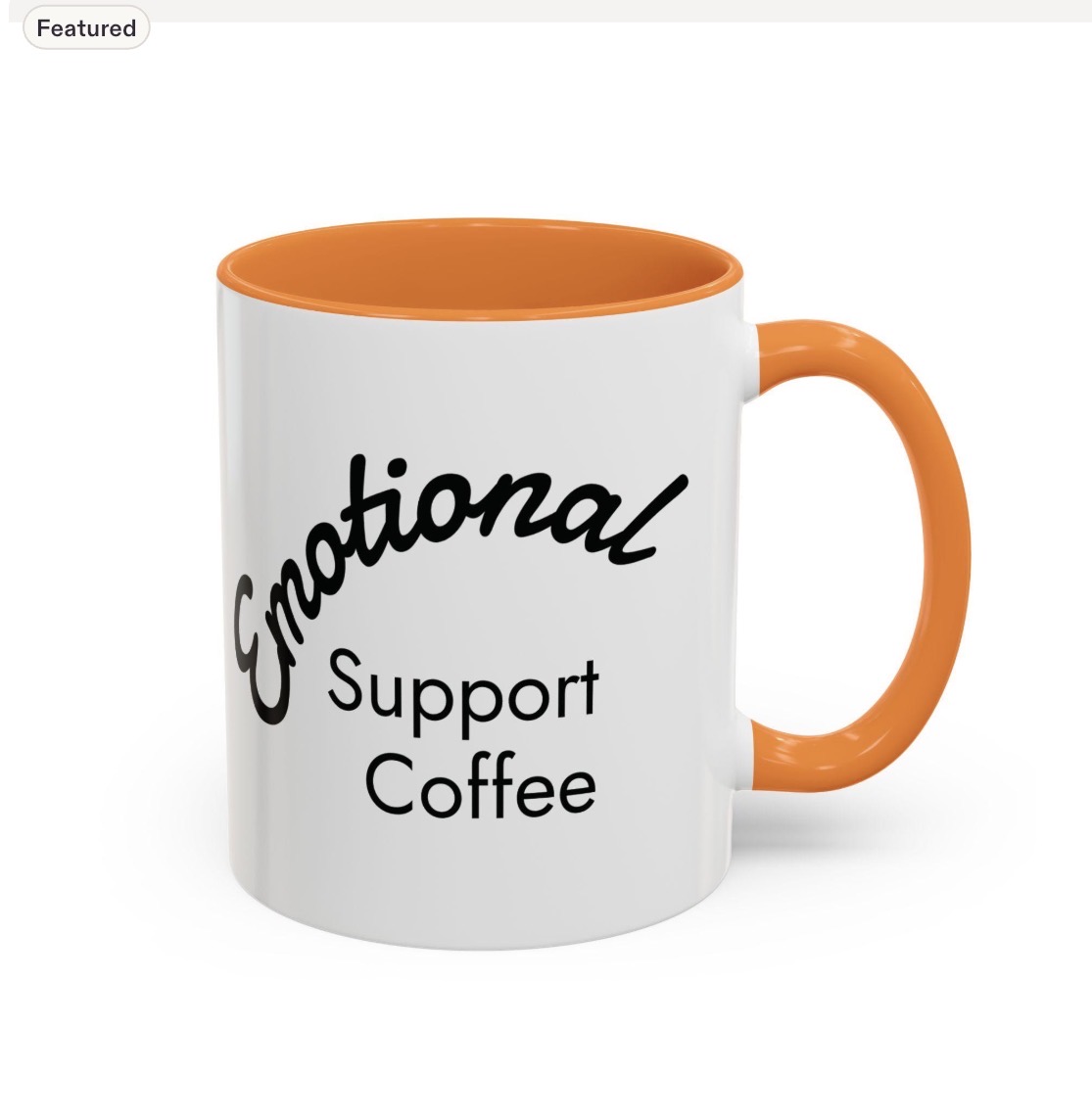 White mug with orange interior and handle, displaying the words 'Emotional Support Coffee' in black text.