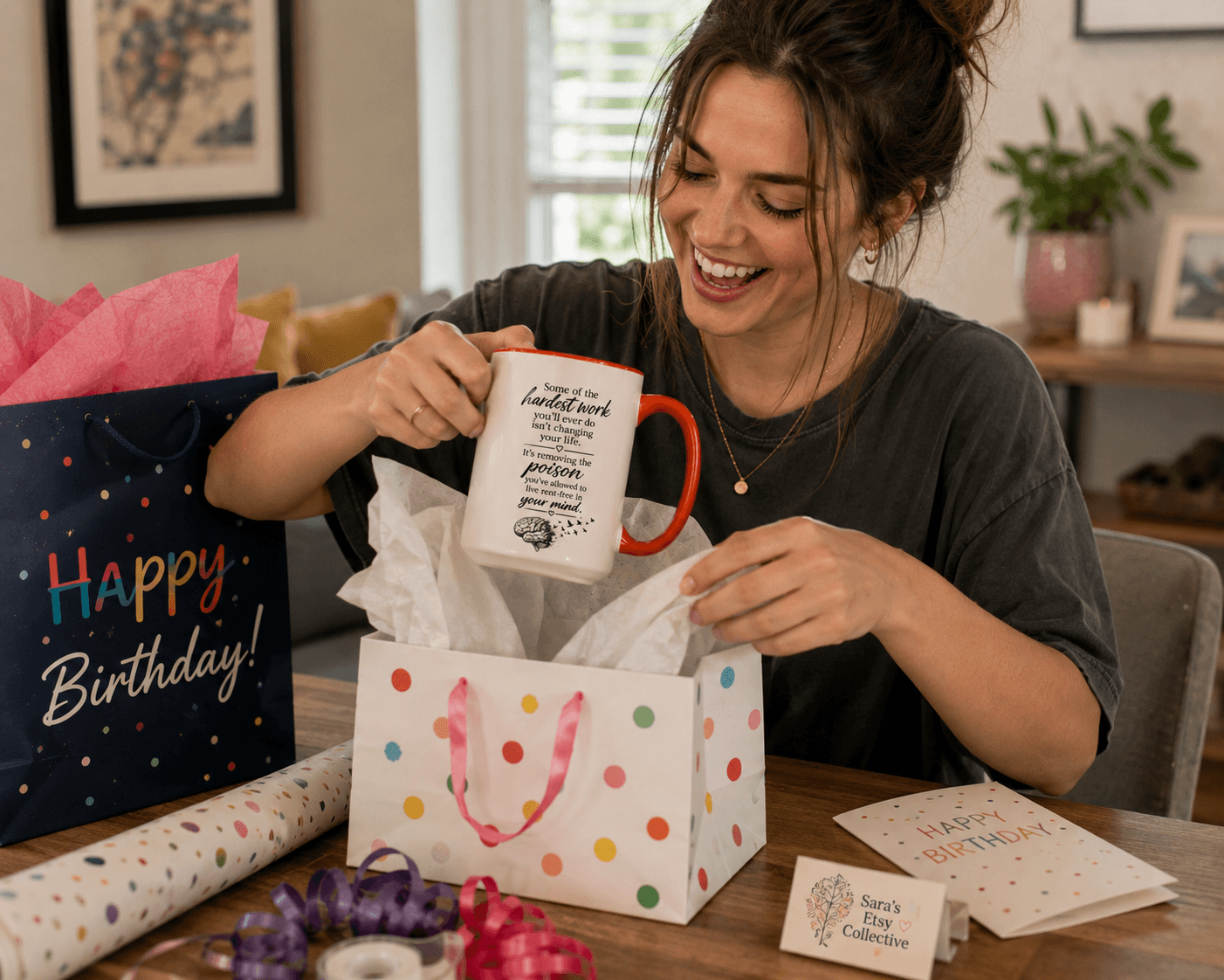Woman opening birthday gift with a smile, surrounded by wrapping paper and a gift bag, in a cozy room.