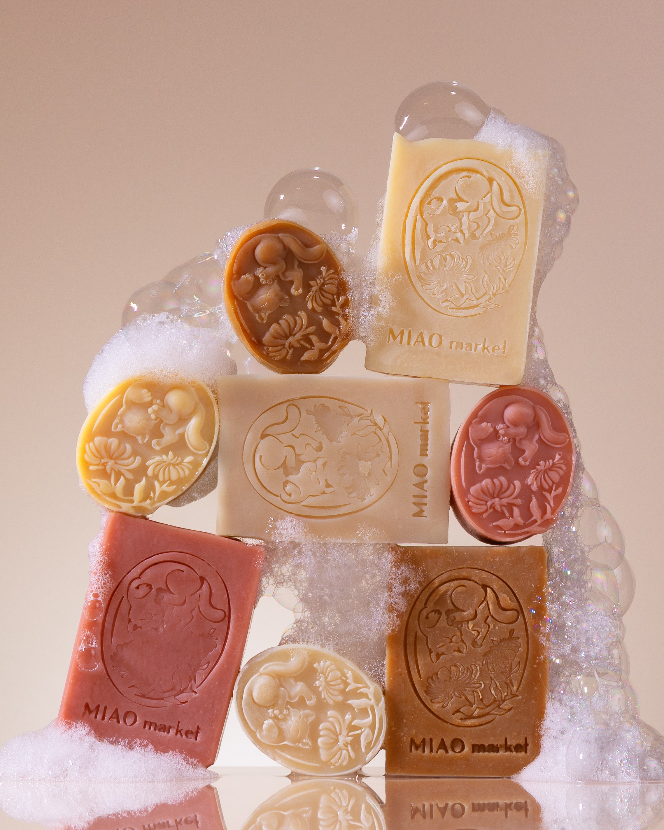 Assorted soap bars with bubbles, in various colors and shapes, arranged on a neutral background.
