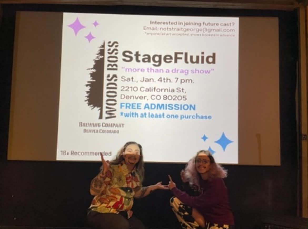 Two women sitting in front of a large screen displaying event details for StageFluid, a drag show, with a white background and colorful text.