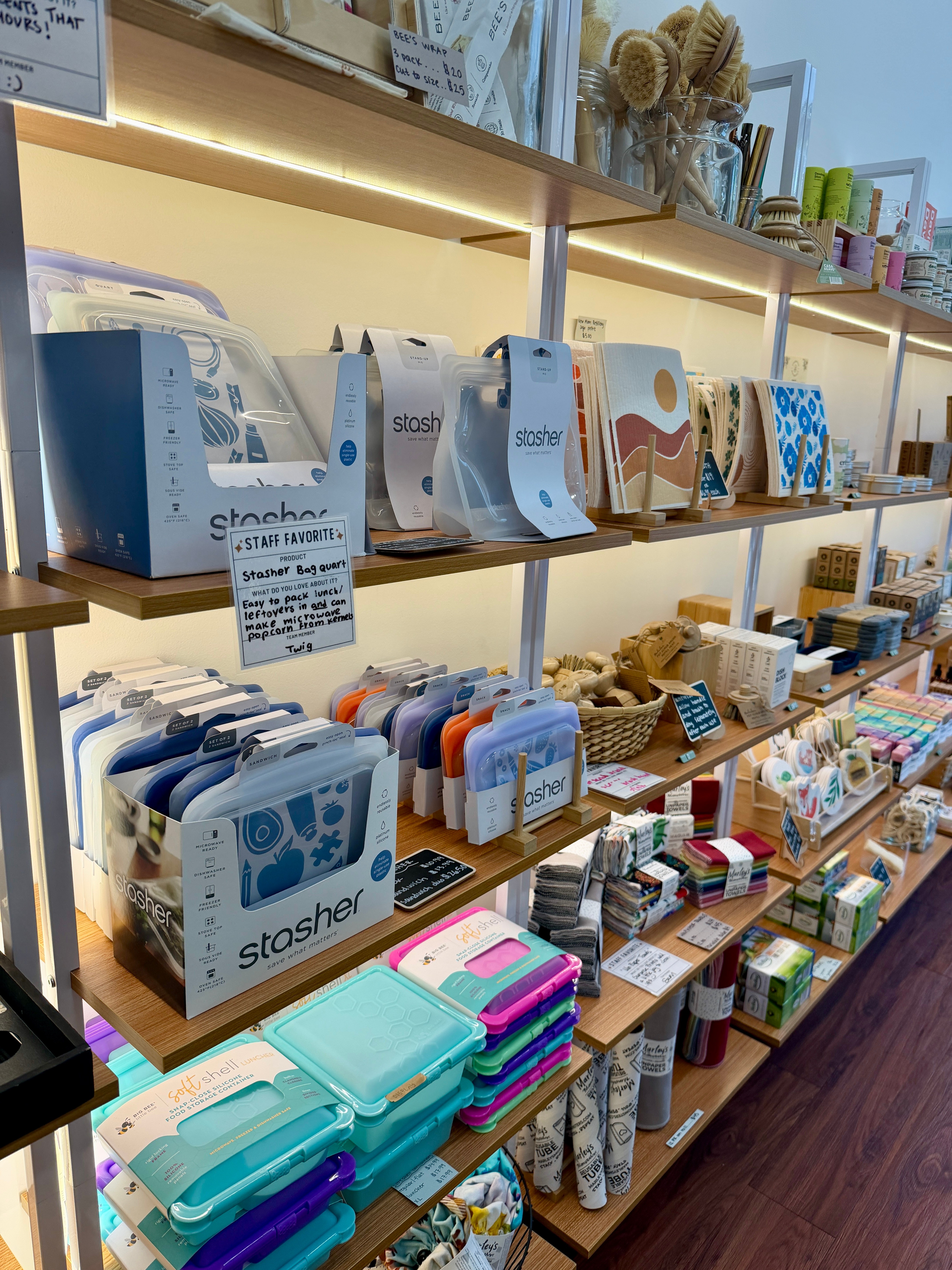 Shelves display various stationery and gift items, including boxes, notebooks, and decorative objects, in a store setting.