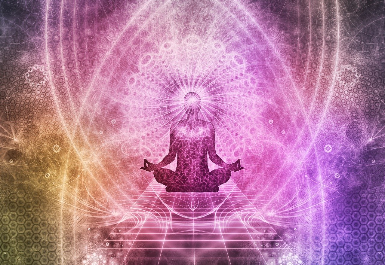 Person meditating in a colorful, abstract, spiritual background with geometric patterns and light effects.