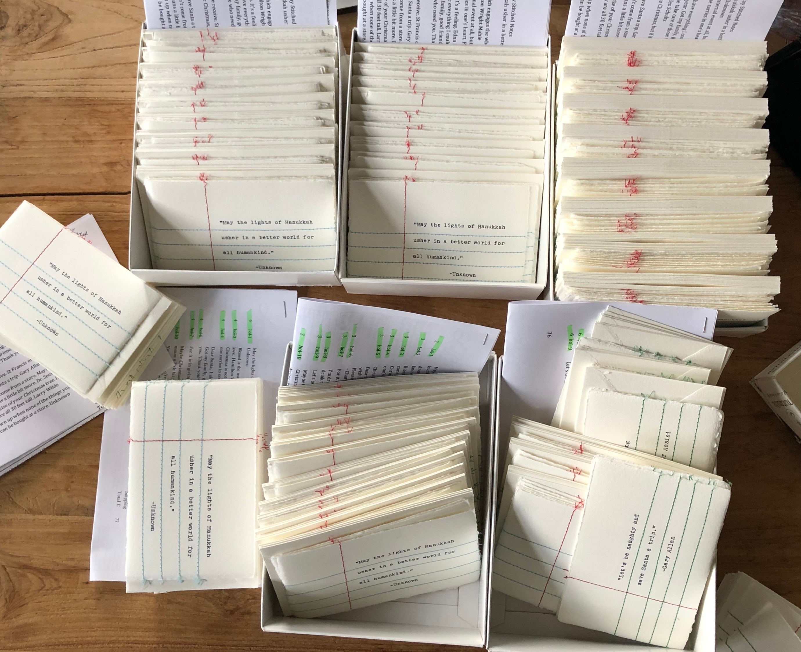 Multiple stacks of white cards with printed text and some with green highlights, arranged on a wooden surface.