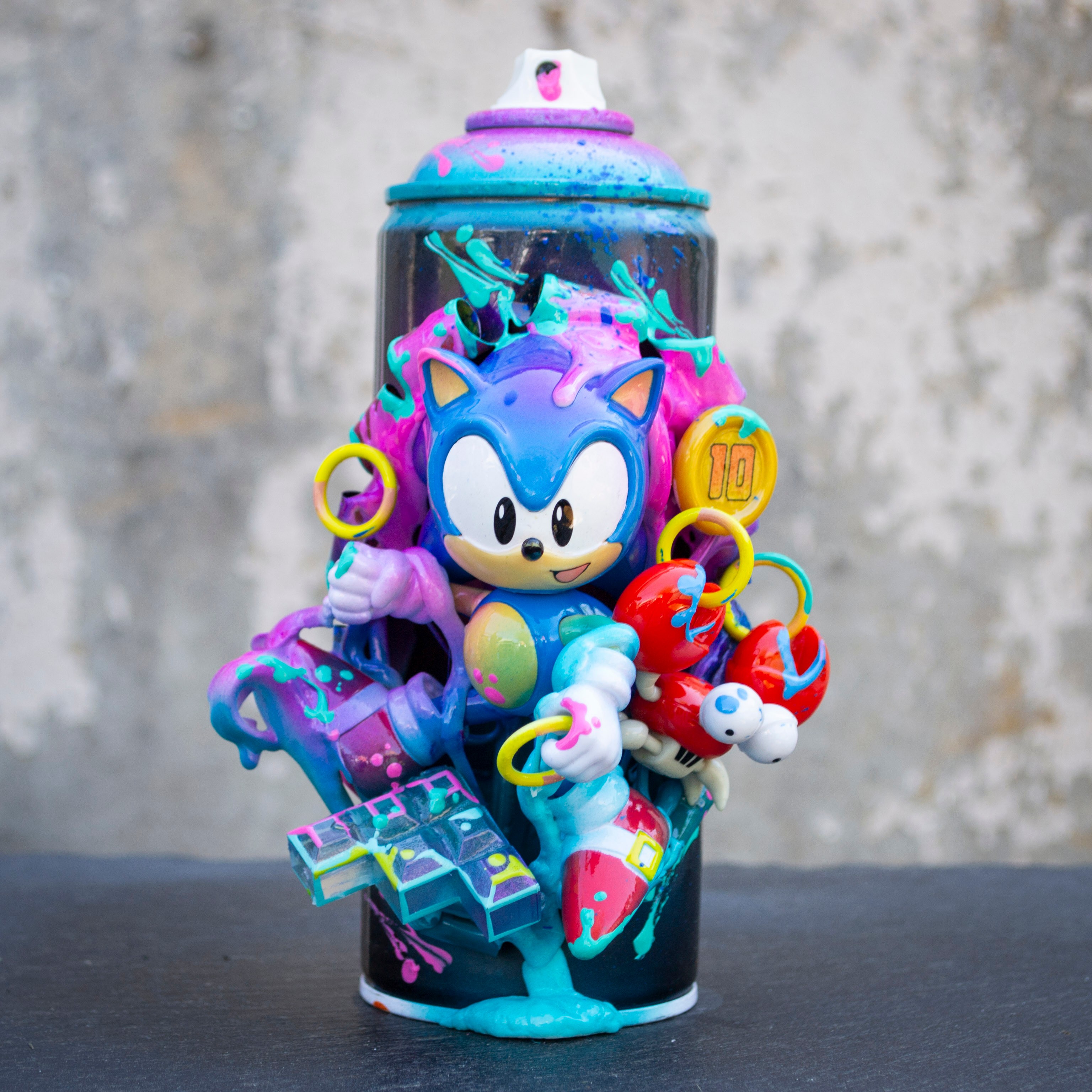 A Sonic the Hedgehog figure inside a spray paint can with colorful accessories and a graffiti background.