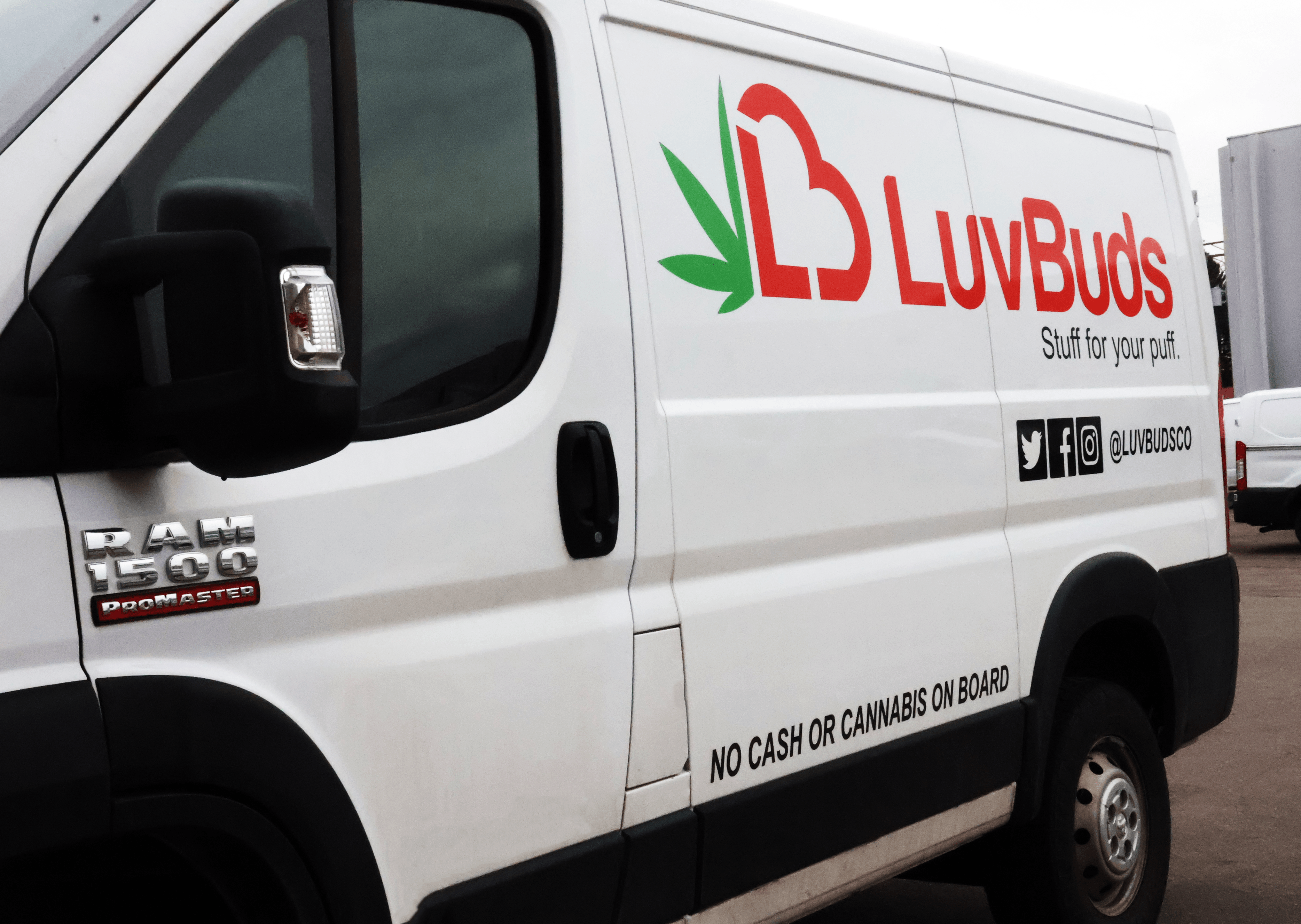 White delivery van with 'LuvBuds' logo, cannabis leaf, and social media icons, parked outdoors.