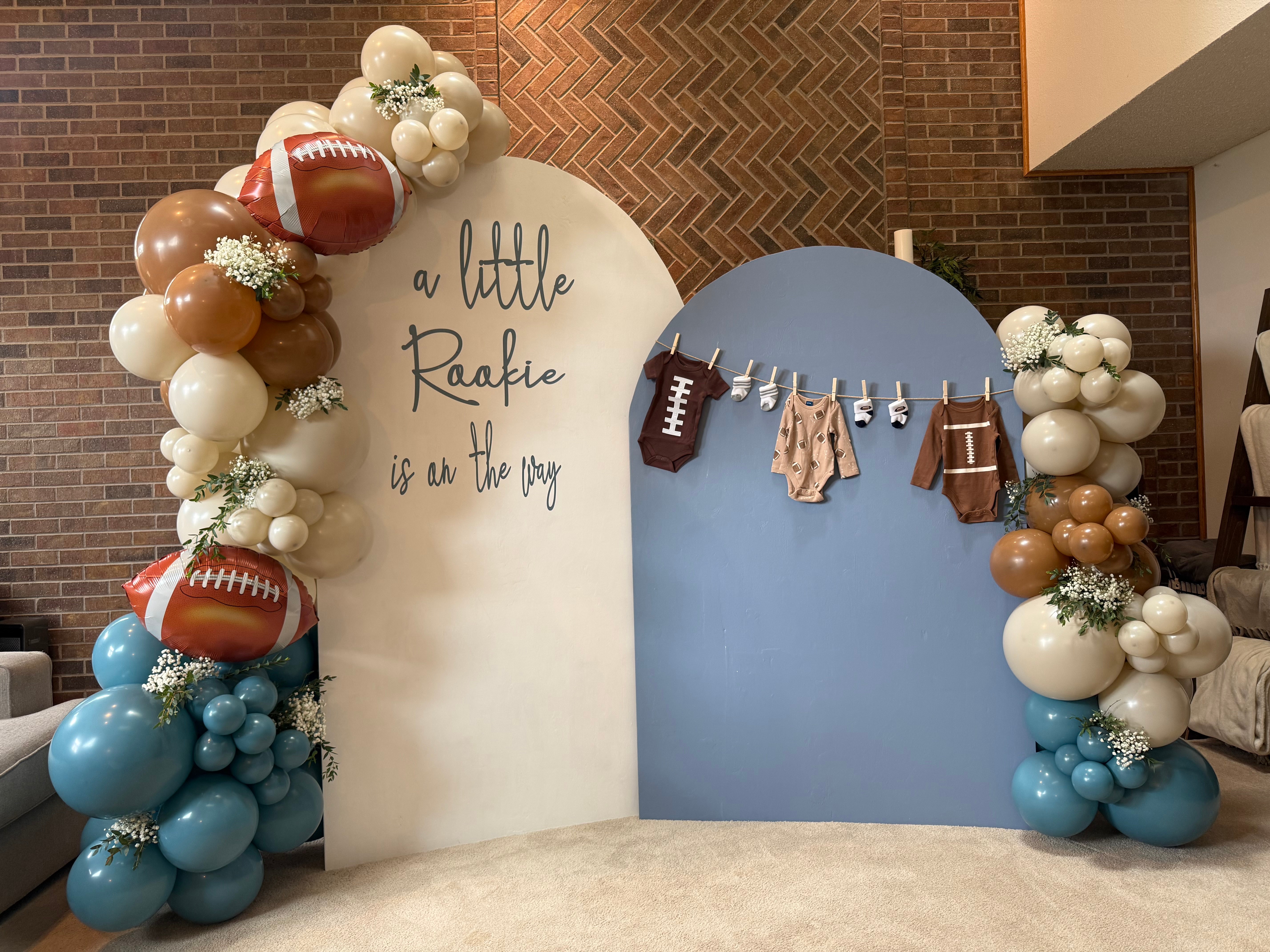Decorative backdrop with football-themed balloons and a white and blue panel, celebrating a little Raafke's birthday.