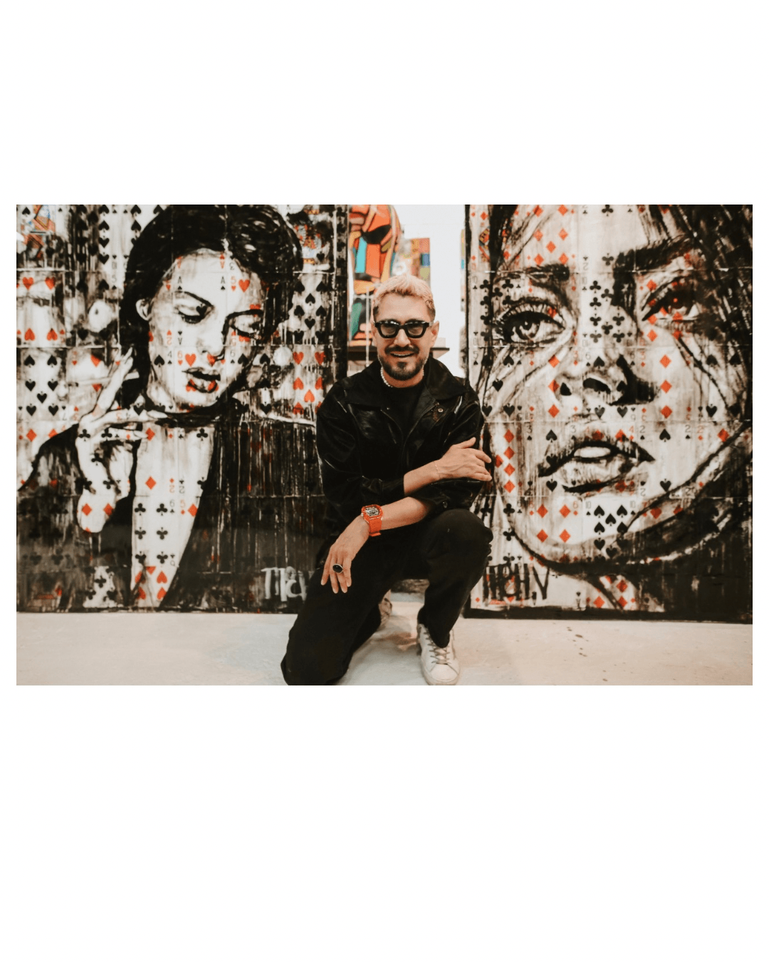 Person crouching between two large black-and-white portraits of women, one with closed eyes and the other with open eyes, in an art gallery.