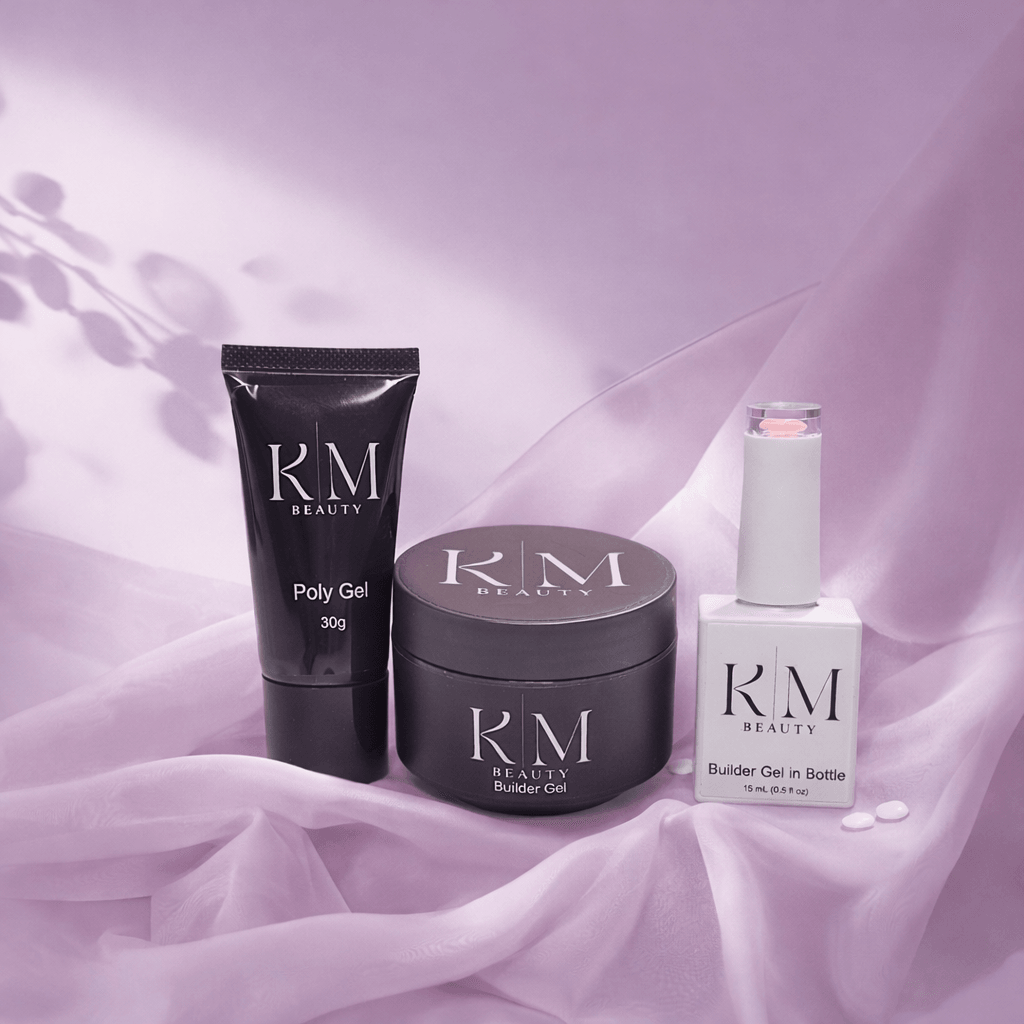Three beauty products on pink fabric: a black tube, a black jar, and a white bottle with pump, all labeled KM Beauty.