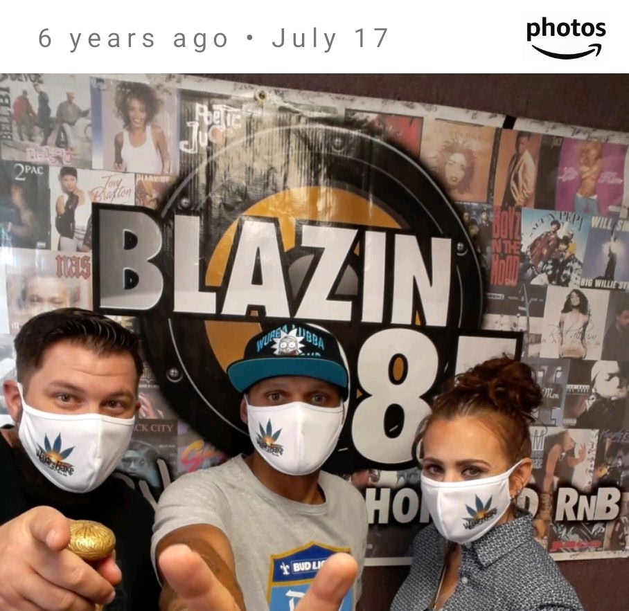 Three people wearing masks with leaf designs, standing in front of a Blazin' 98 logo backdrop.