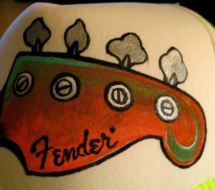 Close-up of a guitar headstock with tuning pegs and the Fender logo, drawn on a surface.