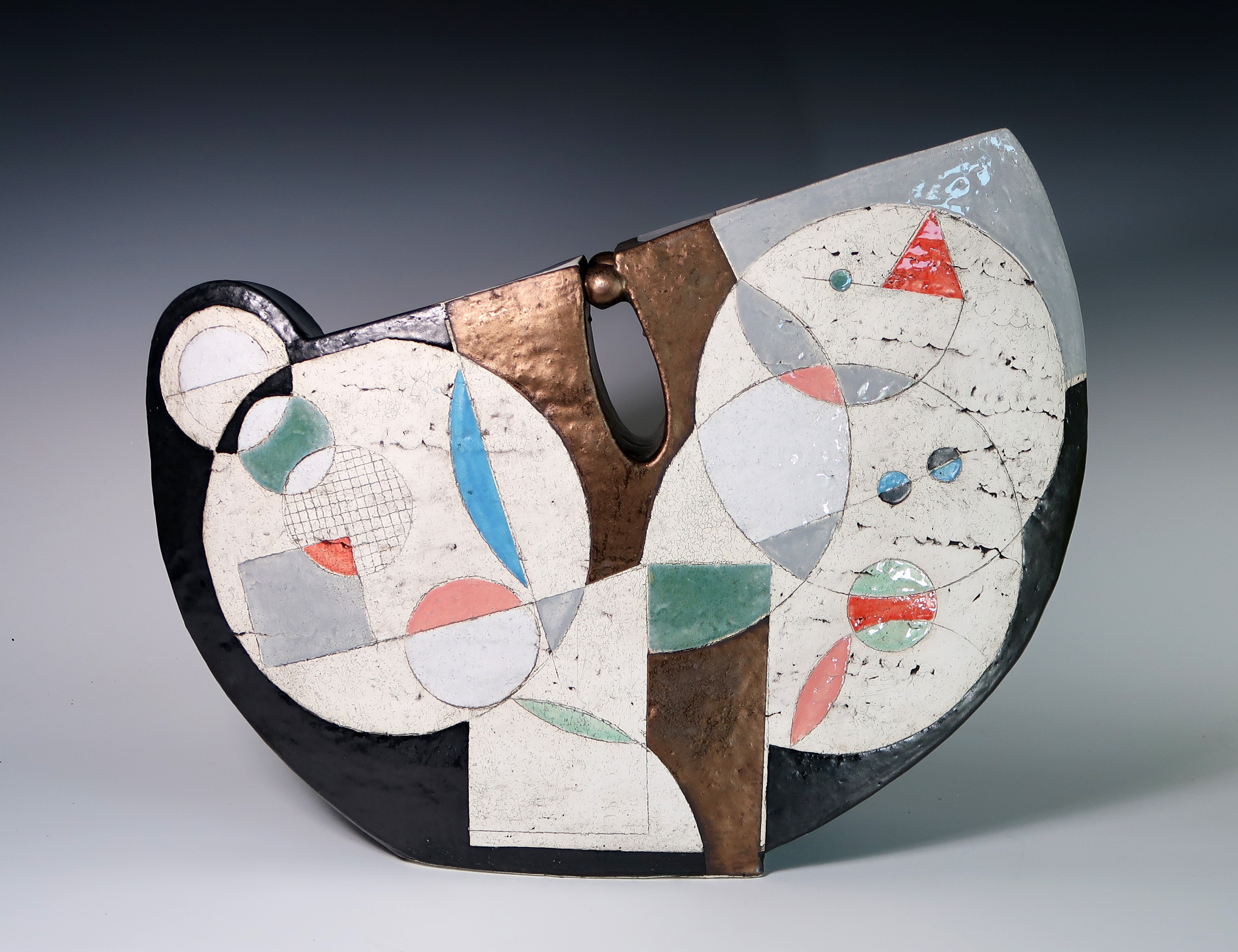 Abstract ceramic sculpture with geometric shapes and colors, featuring circular and triangular elements, on a dark background.