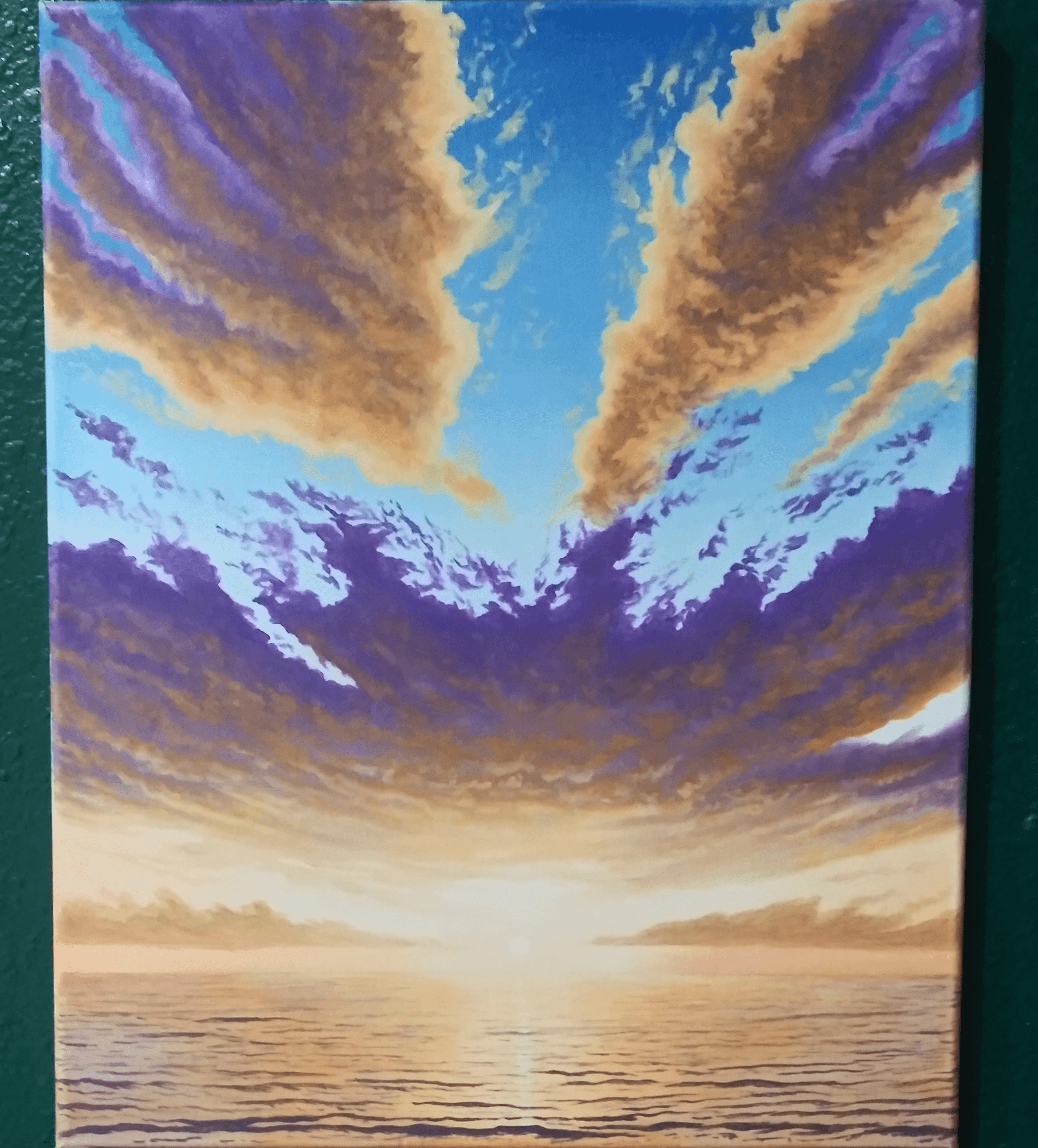 Sunset over the ocean with colorful clouds in the sky, reflecting on the water surface.