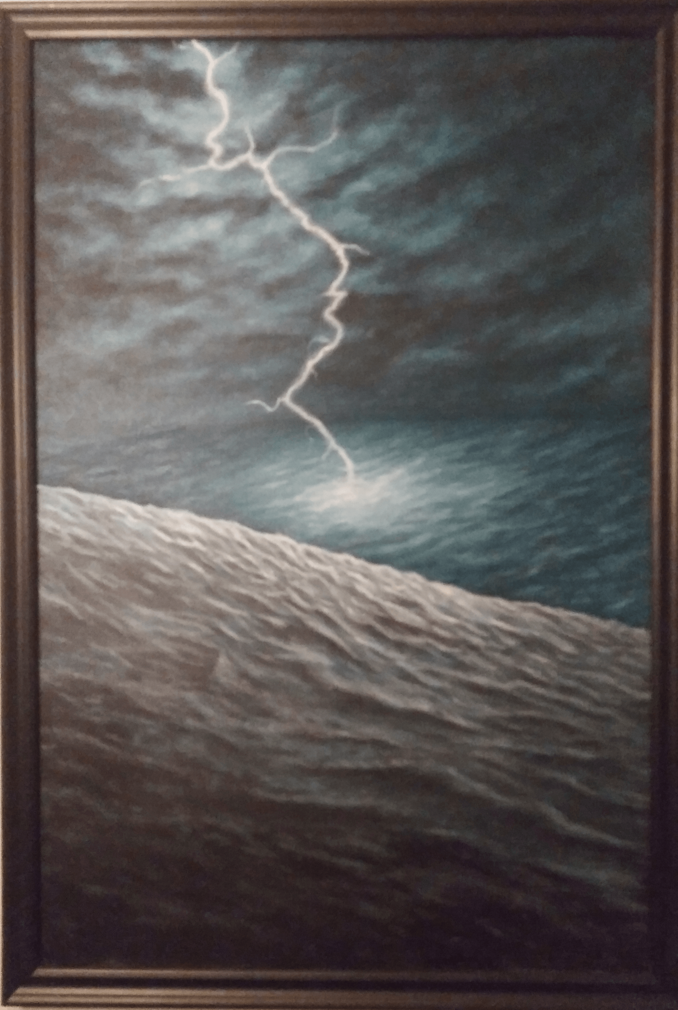 Stormy sky with lightning above a turbulent ocean and a sandy beach in the foreground.