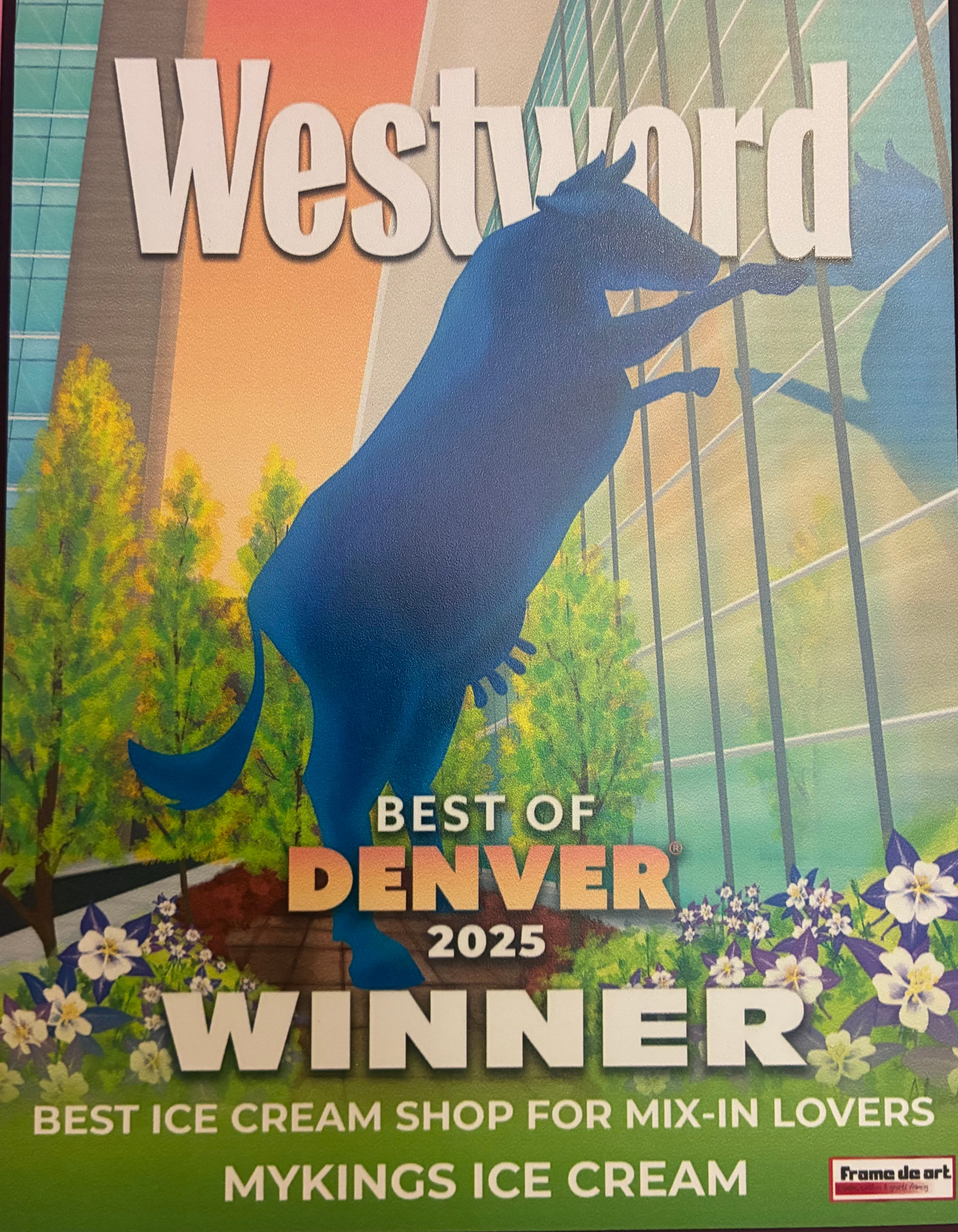 A blue horse sculpture in front of a glass building with trees and flowers, with text about Westword and Denver 2025.
