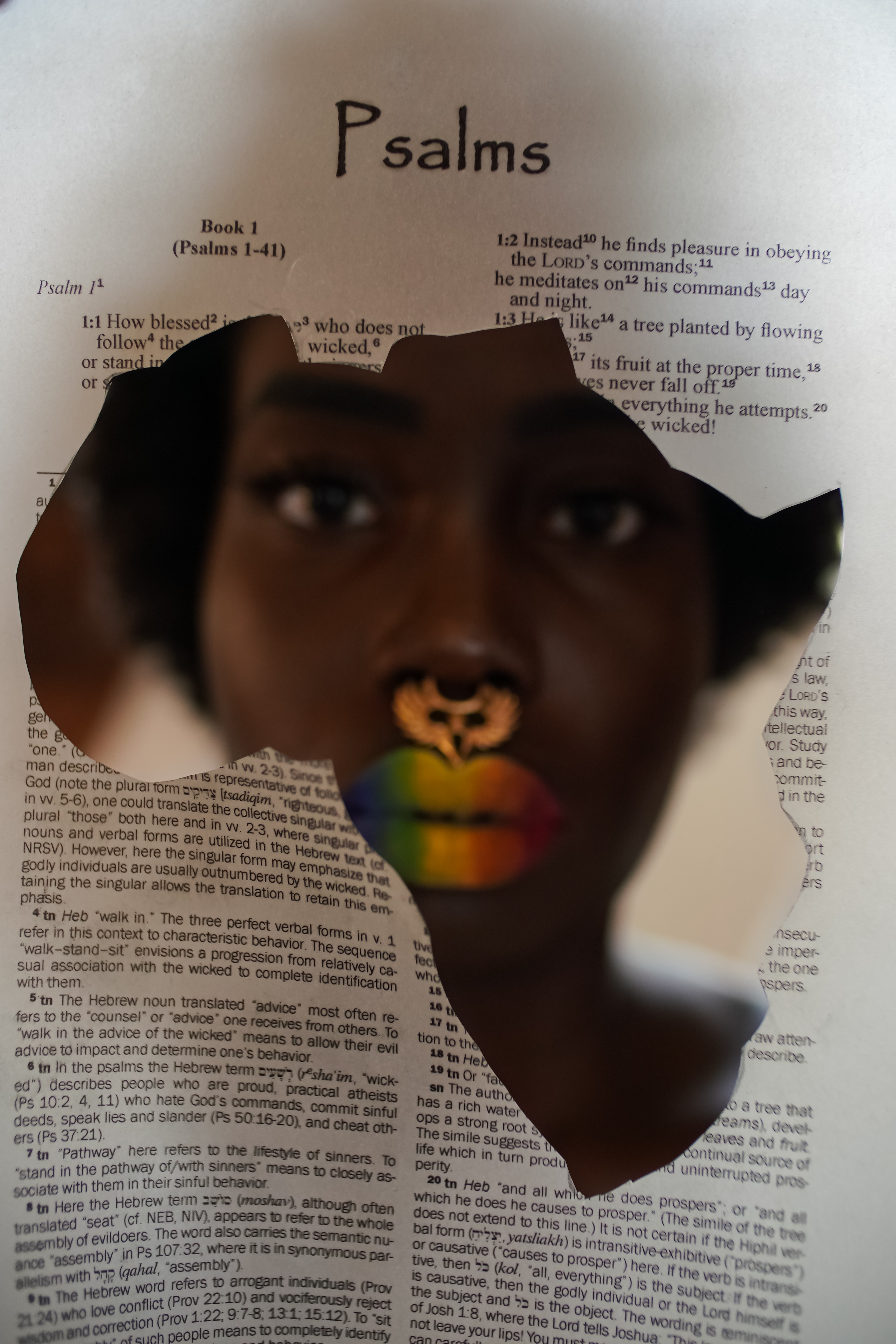 A person's face is seen through a torn paper with a Bible page titled 'Psalms' in the background.