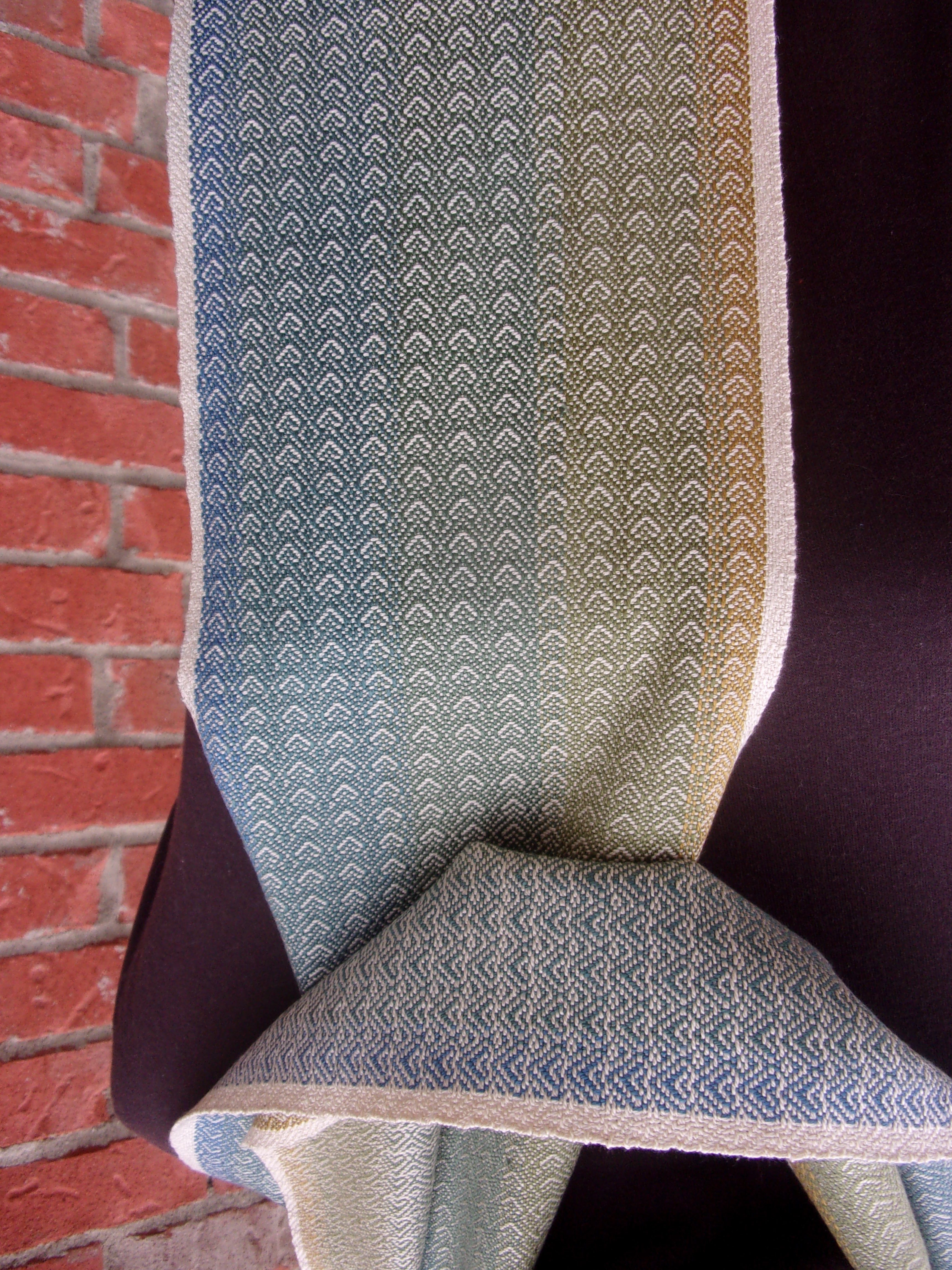 Upright view of a fabric-covered chair with a brick floor background.