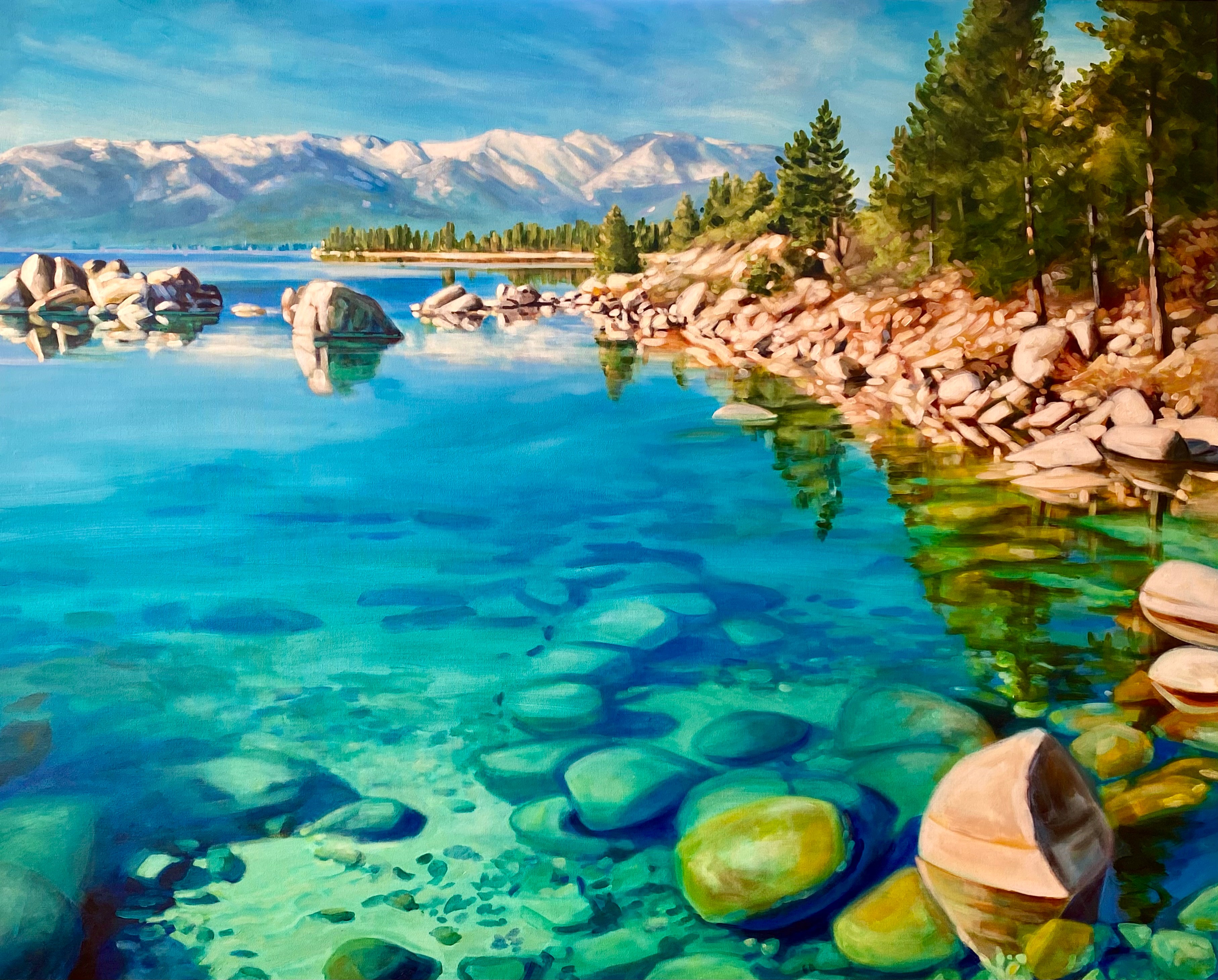 Clear lake with rocks, trees, mountains, and blue sky reflected in water, vibrant and scenic landscape.
